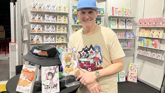 Richard Petit, auteur jeunesse devant un kiosque de ses livres pour enfants au Salon du livre de la Côte-Nord.