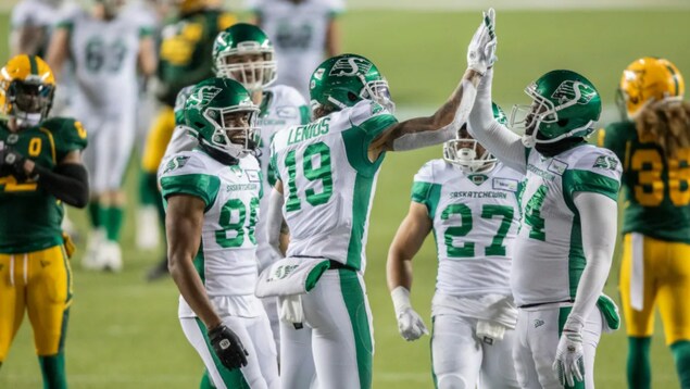 Cinq joueurs de football célèbrent sur un terrain.