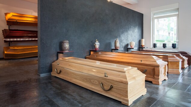 Des cercueils et des urnes dans la salle d'exposition d'un salon funéraire. 