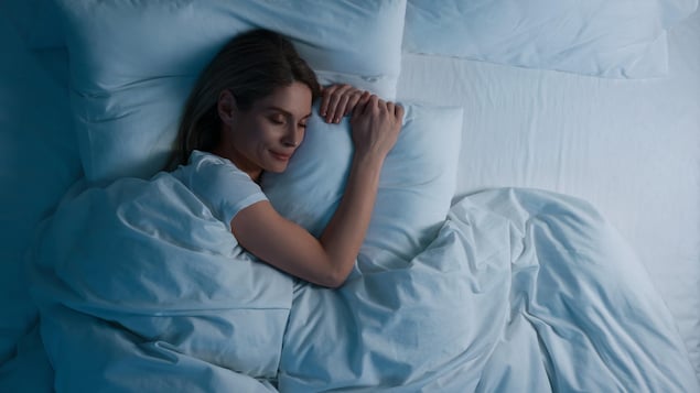 Une femme dormant dans son lit.