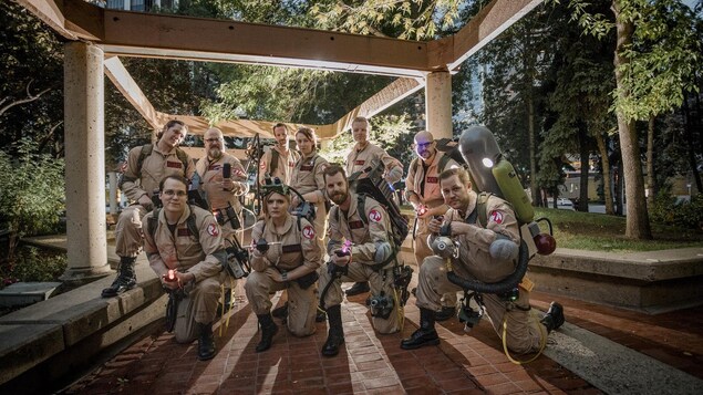 10 membres du groupe Alberta Ghosbusters posent habillés de leur costume de chasseurs de fantômes.