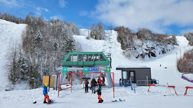 La montagne de ski Gallix enneigée, avec des skieurs, planchistes et le télésiège.