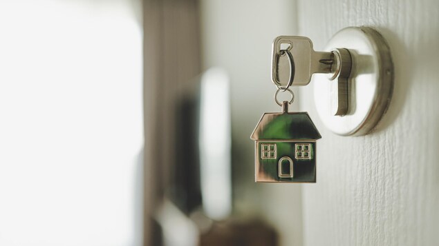 Une serrure avec une clé et une maison en porte clé.