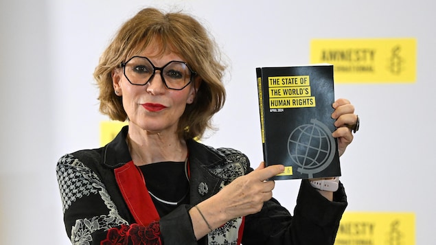 Agnès Callamard montre le rapport annuel sur les droits humains daté d'avril 2024.