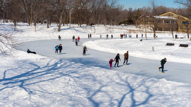 Des gens patinent sur la patinoire du parc La Fontaine à Montréal.