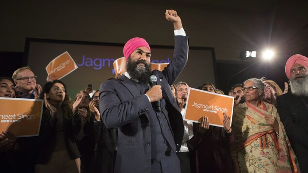 Jagmeet Singh lève le bras en signe de victoire en compagnie de ses partisans.