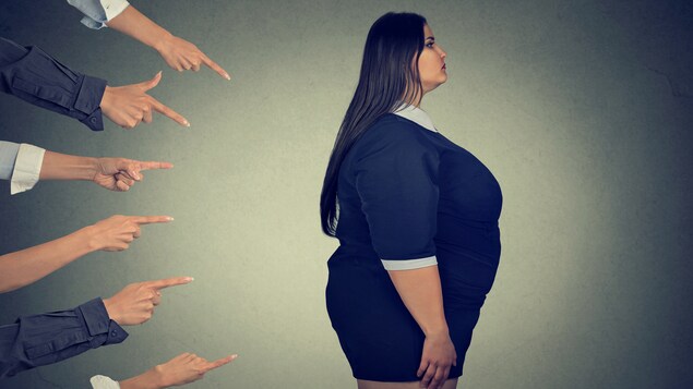 Une femme en surplus de poids est pointée du doigt.