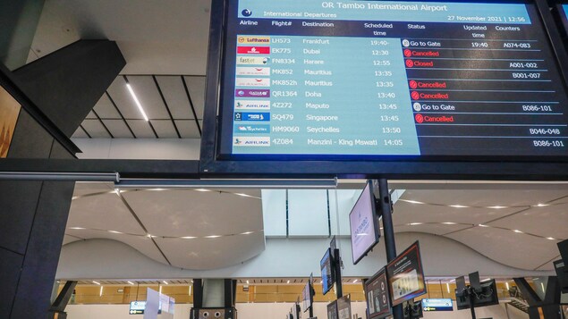 Un tableau d'affichage électronique indique l'état des vols, dont certains sont annulés, à l'aéroport international OR Tambo de Johannesburg, le 27 novembre 2021.