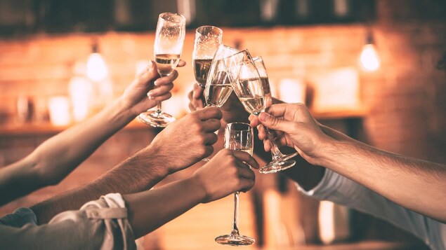 Un groupe de personnes trinque avec des flûtes de champagne.
