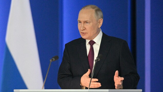 Gros plan sur le président russe, derrière un lutrin, qui prononce son discours annuel sur l'état de la nation au centre de conférence Gostiny Dvor, dans le centre de Moscou, le 21 février 2023. 