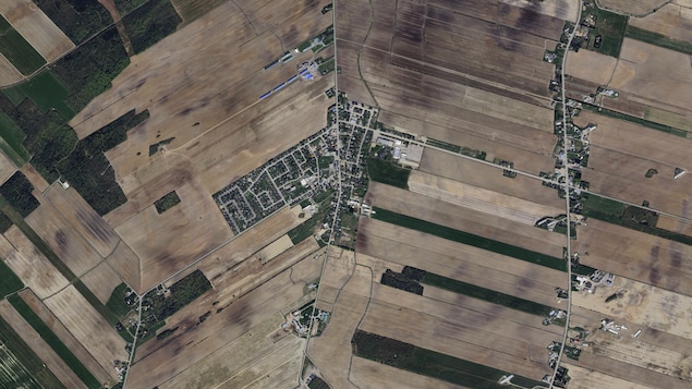 Vue aérienne des champs autour du cœur d'un village.