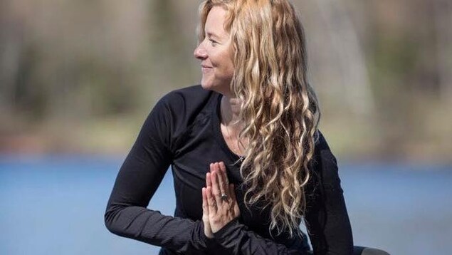 Stéphanie Blain à l'extérieur en train de pratiquer le yoga. 