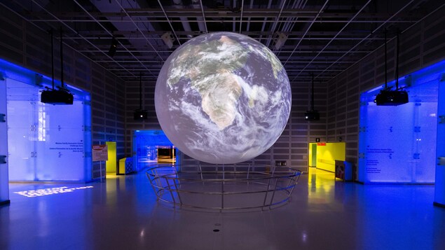 Un globe terrestre géant illuminé au milieu du Centre des science de l'Ontario.