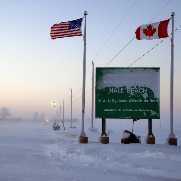 Une enseigne indique le Système d’alerte du Nord à Hall Beach, au Nunavut. Le Système d’alerte du Nord a été signé par le Canada et les États-Unis dans le cadre du NORAD.