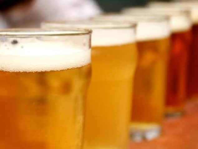 Des verres de bières alignées sur un comptoir.