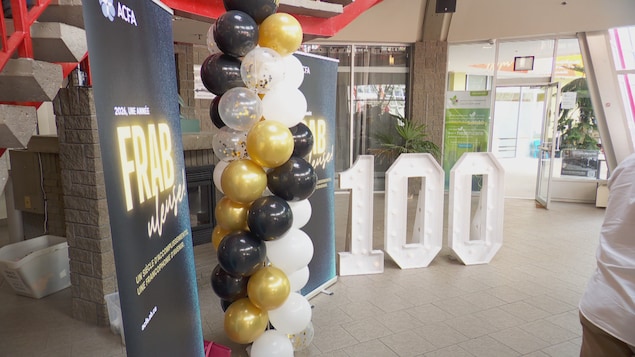 Ballons et gros signe 100 installés dans l'entrée de la Cité francophone à Edmonton. Oct 2026.