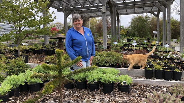 Alice d'Entremont debout et entourée de plantes.