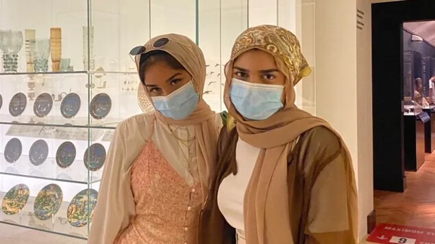 Les deux soeurs côte à côte dans une galerie de musée.