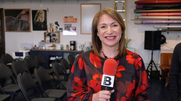Anne-Marie Parenteau tient un microphone.