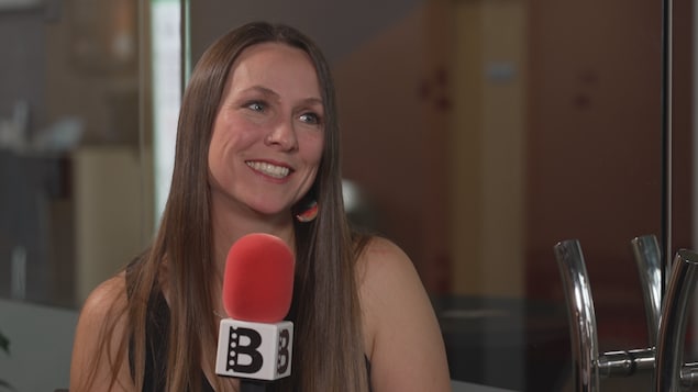 Kristen Martell tenant un microphone.