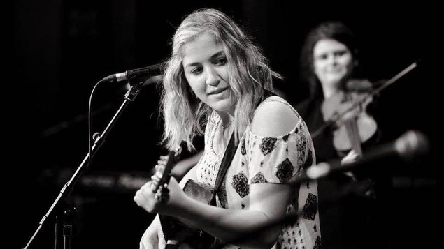 Britney Arsenault sur scène avec une guitare.