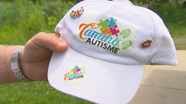 Une casquette sur laquelle il est écrit « Camino autisme ».
