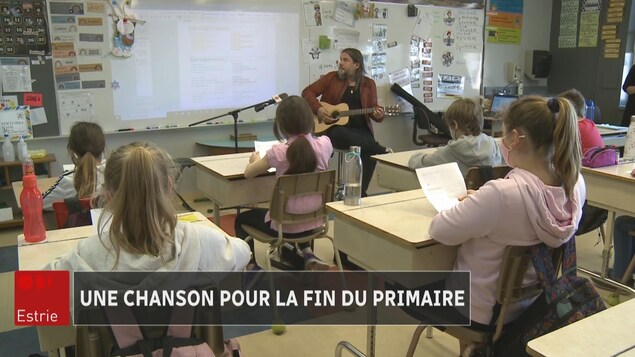 Les élèves en classe écoutent le musicien.