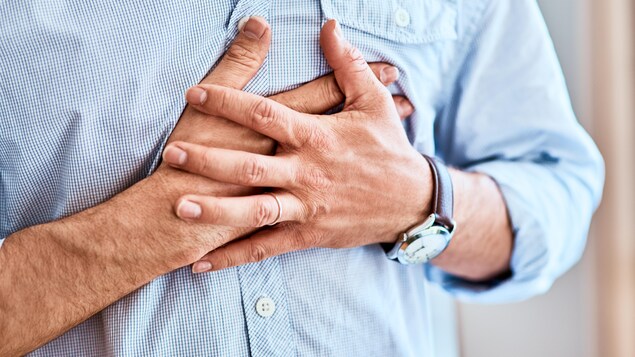 Un homme touche sa poitrine à l'endroit du coeur.