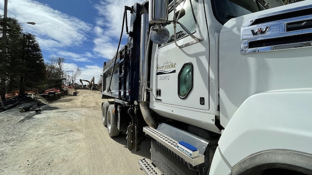 Un camion de la Ville de Sherbrooke devant un chantier de construction .