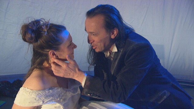 Un homme caresse le visage d'une femme en lui parlant.