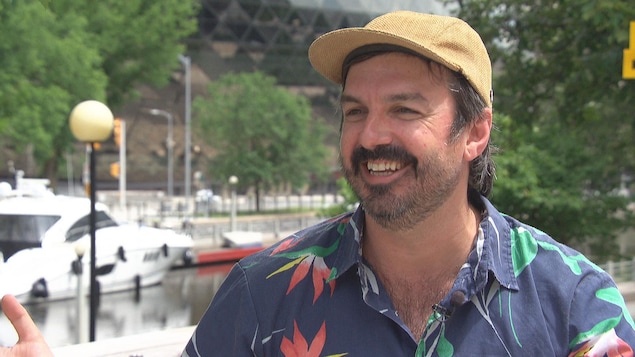 Damien Robitaille, souriant, devant le canal Rideau à Ottawa.