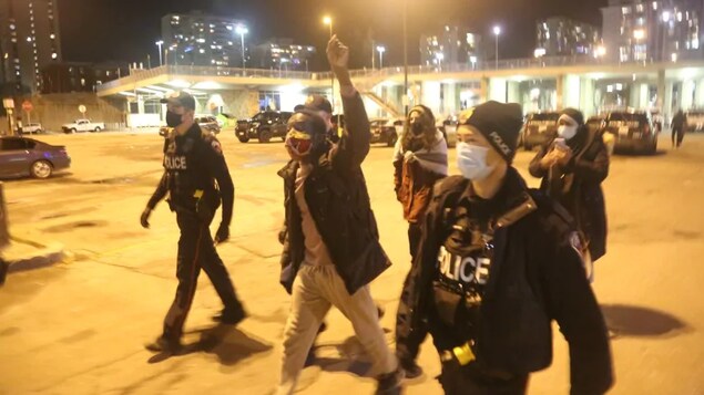 Des policiers entourent Desmond Cole.