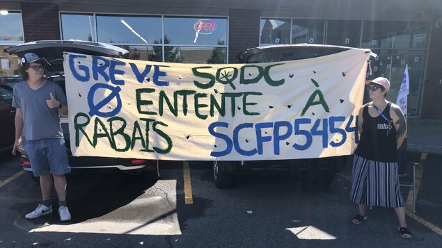 Des manifestants avec une affiche qui indique «Grève SQDC, pas d'entente à rabais SCFP5454». 