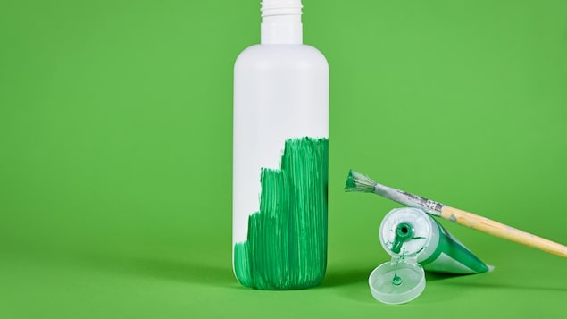 Une bouteille de plastique à moitié peinturée en vert.