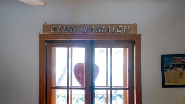 Une fenêtre avec une planche de bois au-dessus sur laquelle il est inscrit : Club Tamalou.