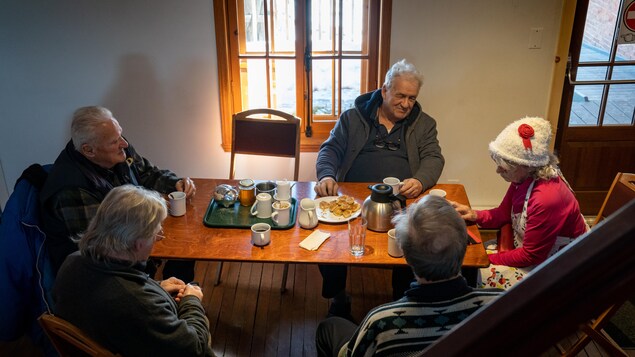 Des aînés assis à la table d'un café qui discutent.