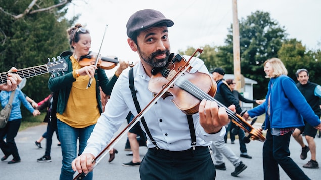 Des musiciens avec des violons qui jouent de la musique dans une rue.