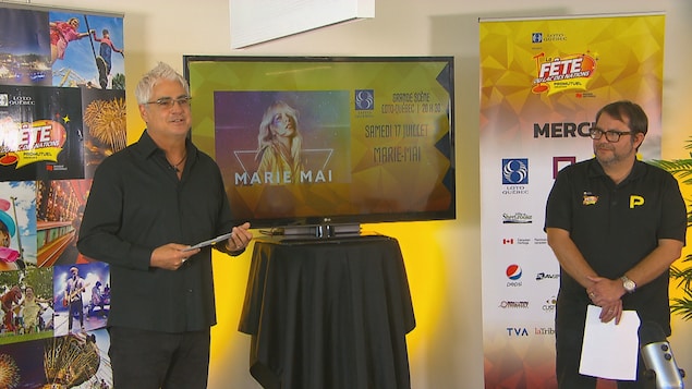 Le directeur général de la Fête du Lac des Nations présente la programmation 2021, devant un écran qui dit "samedi 17 juillet : Marie-Mai".