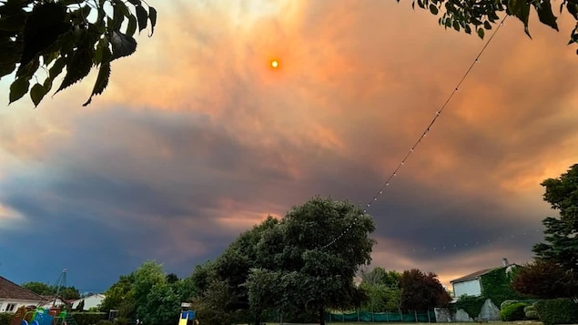 Un ciel rouge orangé, ennuagé par la fumée.
