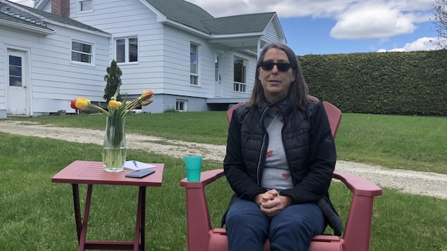 Francine Grenier, assise à l'extérieur.