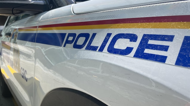 Plan rapproché du mot police en bleu sur un véhicule blanc. Photo prise à Calgary, en Alberta, le 28 juin 2022.