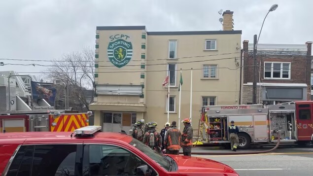 Des pompiers devant un bâtiment.