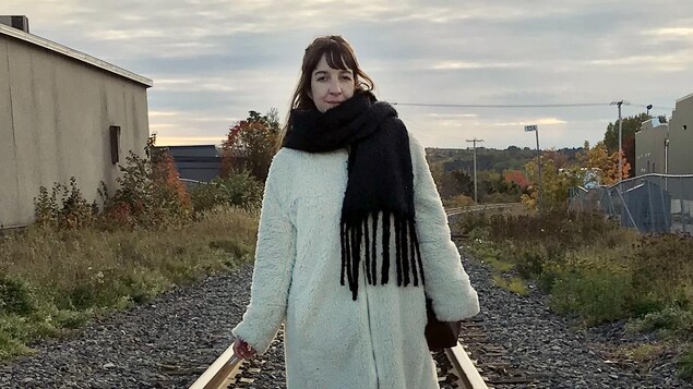 Iris Boudreau, debout au milieu d'un chemin de fer.
