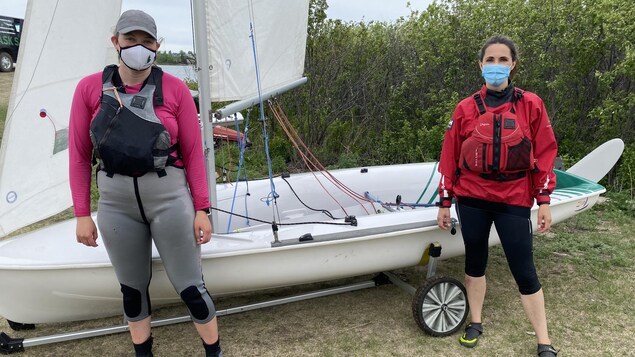 Les deux femmes debout avec le voilier en arrière plan.