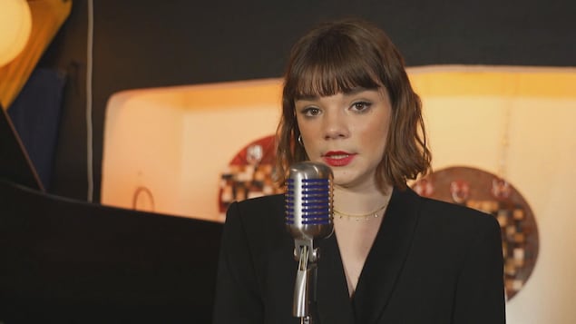 Laura Anglade chante derrière un micro.