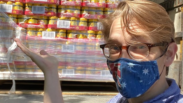 Leighton Walters devant l'arrière d'un camion rempli de caisse de Vegemite.