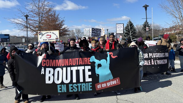 Des personnes qui tiennent une affiche.