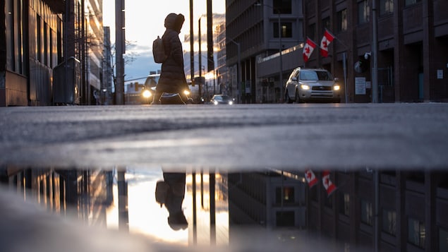 Une dame traverse la rue à Ottawa.