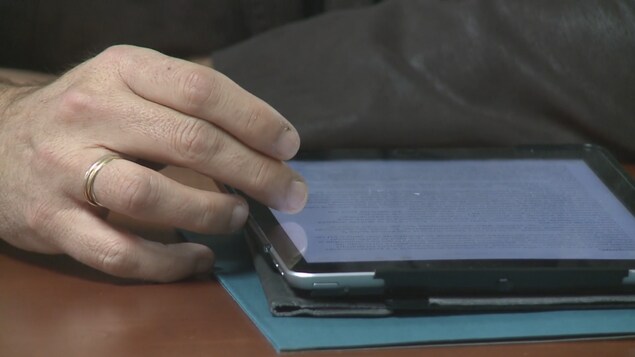 Une personne consulte une tablette électronique.