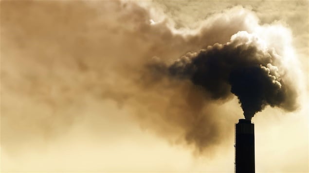 Une tour rejette une grande quantité de fumée dans l'atmosphère.